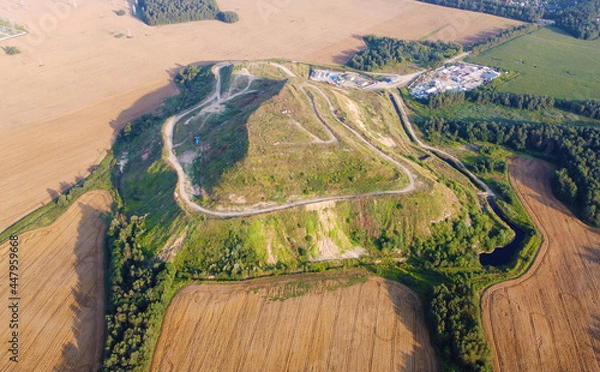 Fototapeta Aerial view of a large green hill in the fields. Ecology pollution garbage landfill