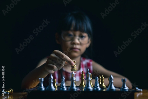 Fototapeta young child playing chess board game for strategy and intelligance game concept. 