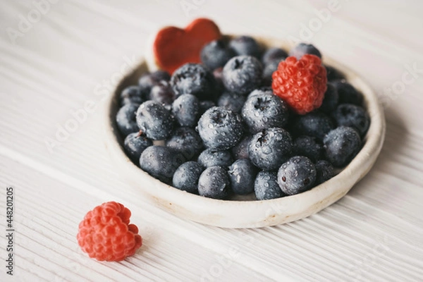 Fototapeta blueberries in a small ceramic bowl with a red heart decor