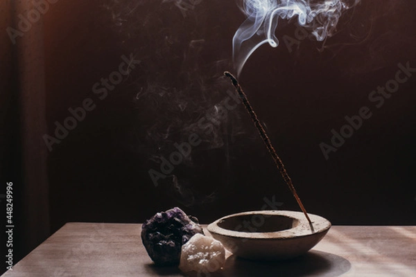 Obraz A stick of incense is burned in a room, it emanates aromatic smoke, it is accompanied by crystals.
Aromatherapy, energetic cleansing, relaxation, ritual.