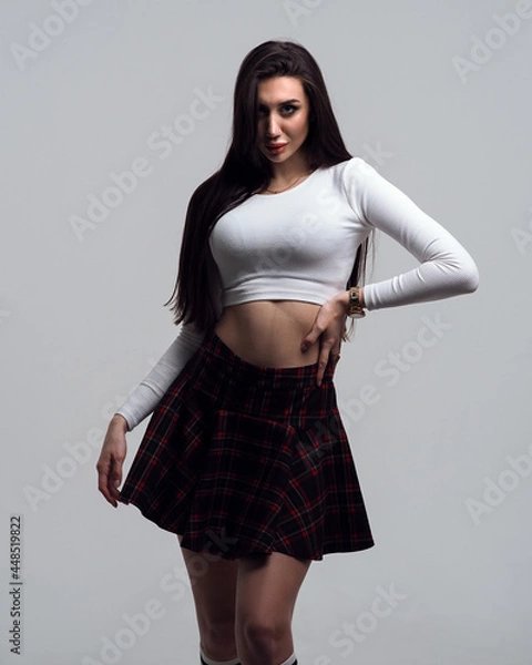 Obraz Woman in plaid skirt in the form of a schoolgirl on a white isolated background