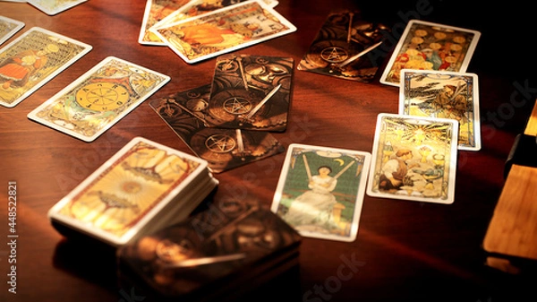 Fototapeta Blurred tarot cards on the table, esoteric concept, fortune telling predictions