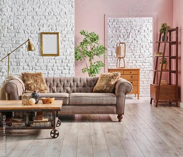 Fototapeta Grey and brown classic sofa with blanket and pillow in front of the white brick and pink wall background, gold lamp, frame and bookshelf, wooden cabinet style, home interior concept.