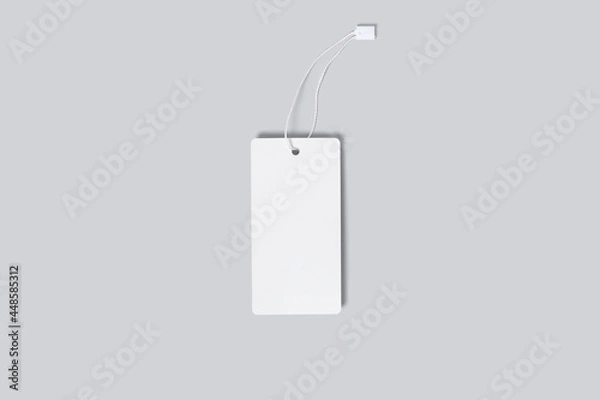 Fototapeta Mockup of a vertical empty white tag for clothes on a gray background. Template for your logo, design
