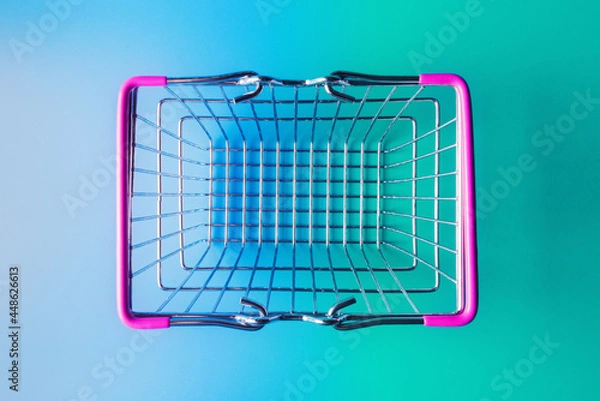 Fototapeta Empty shopping basket over turquoise-blue background. Top view