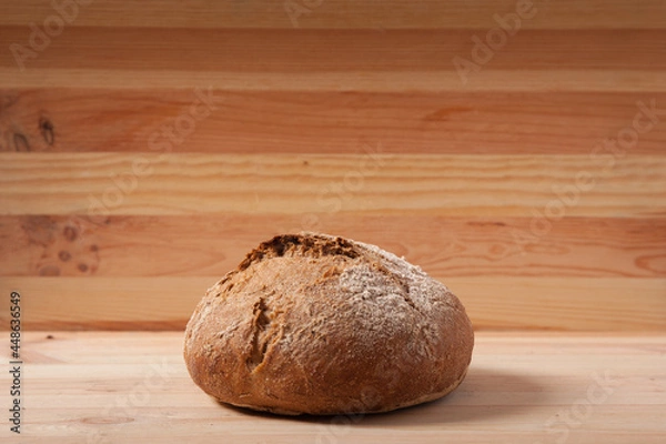 Obraz Handmade fresh wheat bread on wooden background in the morning light. horizontal frame side view with space area for text or design