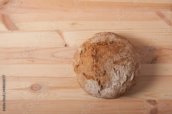 Obraz Handmade fresh wheat bread on wooden background in the morning light. horizontal frame top view with space area for text or design