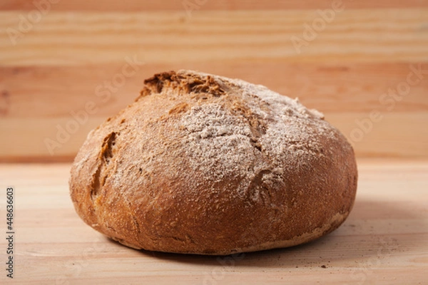 Obraz Handmade fresh wheat bread on wooden background in the morning light. horizontal close-up frame side view