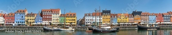 Fototapeta Panorama view of Nyhawn, the colorful houses next to the old port. Tourist visiting restaurants, cafes and ships in the canal. The most important sightseeing spot in Copenhagen, Denmark.