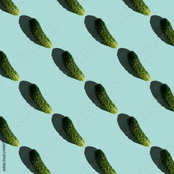 Fototapeta Fresh cucumbers on a blue background. Pattern of cucumbers. Top view. Banner. Pop art design, creative summer food concept. Green cucumbers, minimal flat lay style.