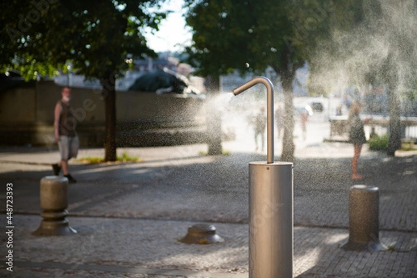 Fototapeta Mist machine installed on a public place to cool down the air. Equipment helps lowering the heat wave in the city.