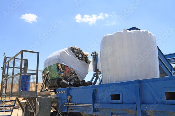 Obraz Garbage packing machine in landfill