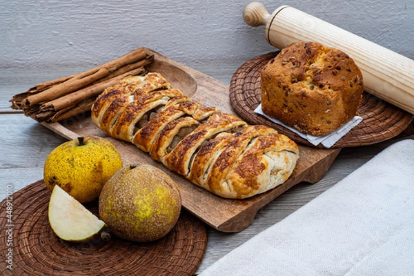 Fototapeta Pear strudel baked pie, with pancake and cinnamon in a wooden board  