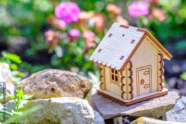 Fototapeta toy house on stone with greenery background