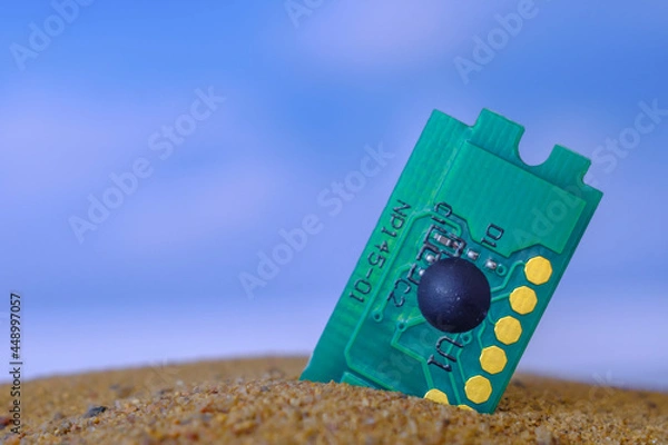 Fototapeta microcircuit lying on the sand against the background of the sky