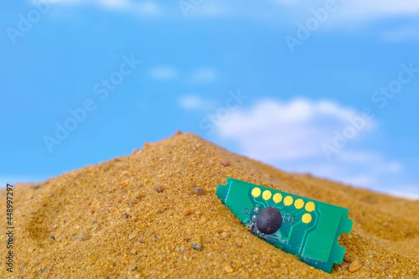Fototapeta microcircuit lying on the sand against the sky background