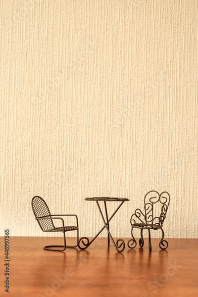 Fototapeta toy iron chairs and table on a beige wall background
