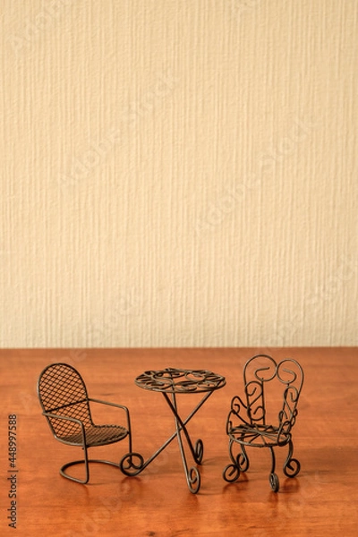 Fototapeta toy iron chairs and table on a beige wall background