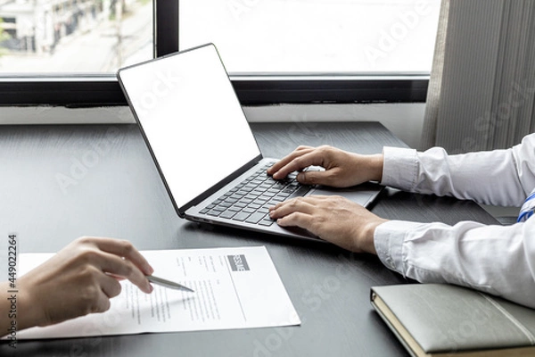 Fototapeta The atmosphere of the job interview room has HR and job applicants checking resumes, HR is typing applicants' information into laptops to send information to the system to the department manager.