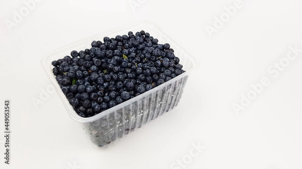 Obraz blueberries in a plastic black box insulated on white. sale of summer berries.