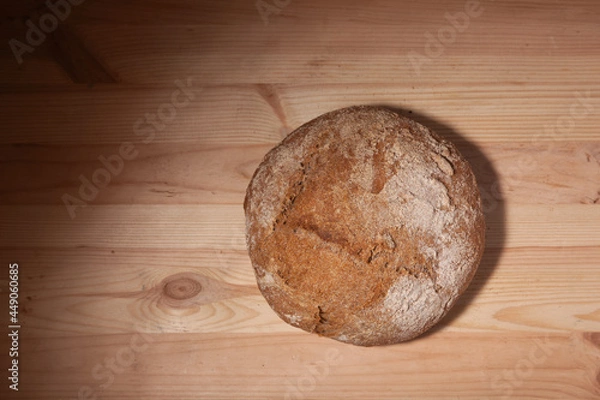 Obraz Handmade fresh wheat bread on wooden background in the contrast light. horizontal frame top view with space area for text or design