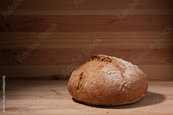 Obraz Handmade fresh wheat bread on wooden background in the contrast light. horizontal frame side view with space area for text or design