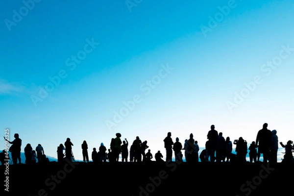 Fototapeta Silhouettes of tourist crowd waiting for the sunrise and doing activity, taking a photo, selfie with nature on the hill at viewpoint