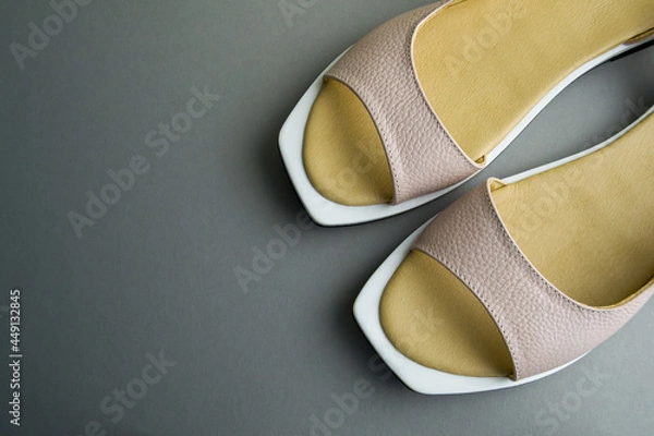 Fototapeta women's beige shoes lie on a gray background. Shoes are located at an angle to the horizon