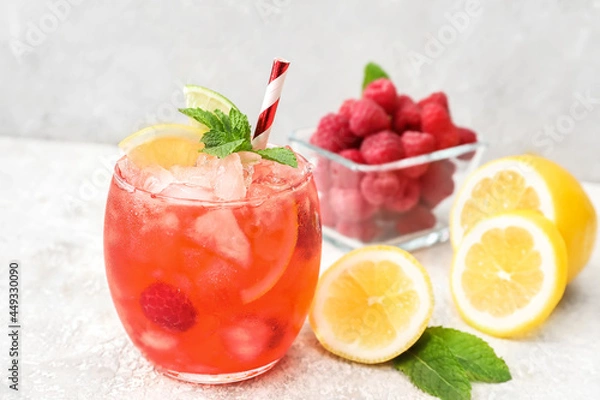 Fototapeta Glass with tasty raspberry lemonade on light background