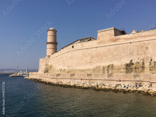 Fototapeta The Fort Saint Jean with the large round Tour du Fanal tower, one of the most visited monuments in Marseille. It is connected to the former port by a footbridge.
