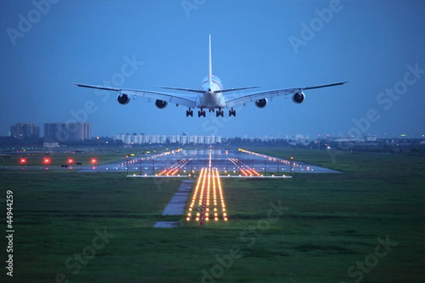 Fototapeta samolot pasażerski przeleciał nad pasem startowym z lotniska