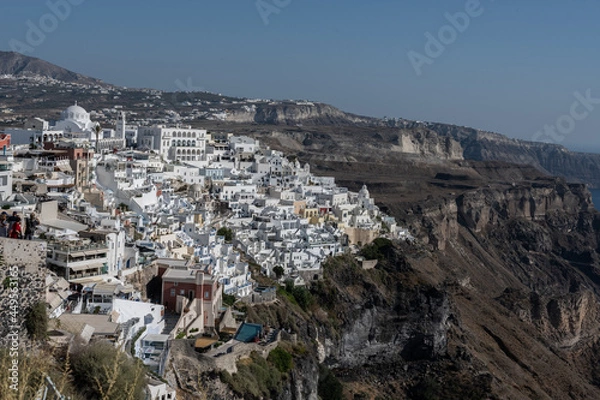 Fototapeta White top of buildings in Santorini, Greece with blue sky in a sunny warm day in July 2021.