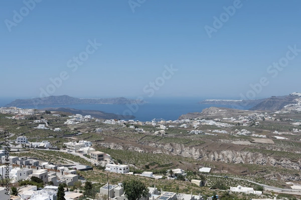 Fototapeta White and blue top of buildings in Pyrgos Santorini, Greece with blue sky in a sunny warm day in July 2021.