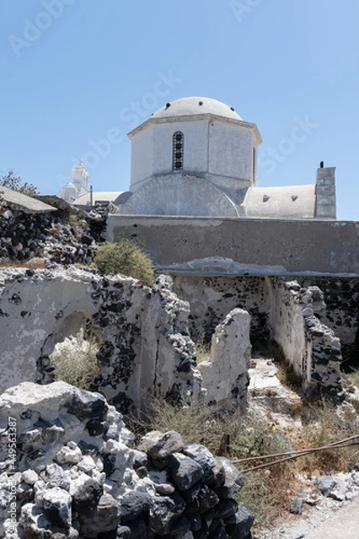 Fototapeta White and blue top of buildings in Pyrgos Santorini, Greece with blue sky in a sunny warm day in July 2021.
