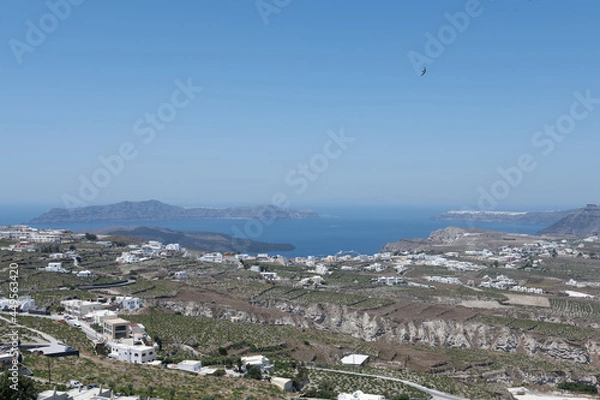 Fototapeta panoramic White and blue top of buildings in Pyrgos Santorini, Greece with blue sky in a sunny warm day in July 2021.