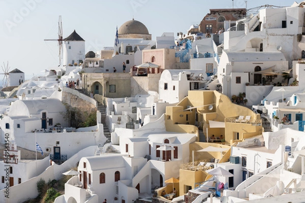 Fototapeta White and blue top of buildings in Pyrgos Santorini, Greece with blue sky in a sunny warm day in July 2021.