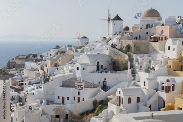 Fototapeta White and blue top of buildings in Pyrgos Santorini, Greece with blue sky in a sunny warm day in July 2021.