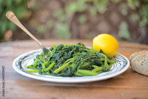 Fototapeta Amaranthus blitum. Vlita Salad (Amaranth Greens) on a plate, on a wooden old table