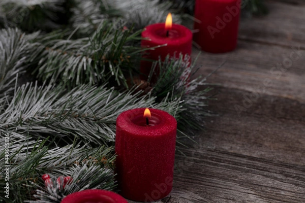 Obraz Red glowing candles with fir and wood dark background for a merry Christmas or happy New Year celebration concept
