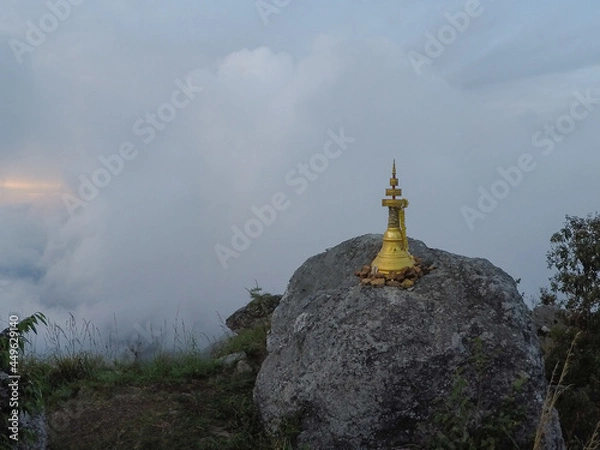 Obraz A viewpoint for sunset on the top of the hill where the pagoda is located, where the atmosphere is filled with mist that obscures the sun's rays.