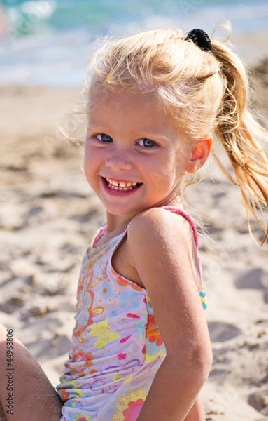 Fototapeta Девочка сидит на песке у моря