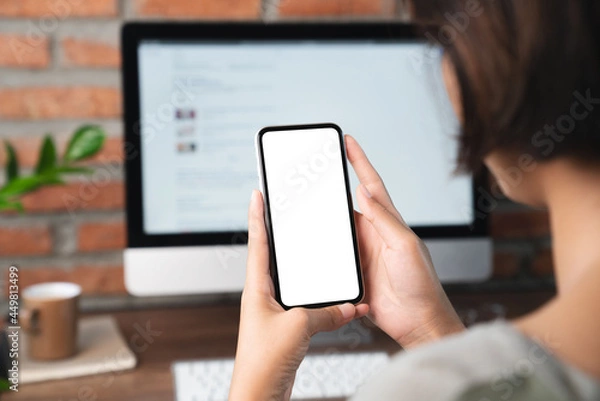 Obraz female holding phone blank screen third person view clippig path inside