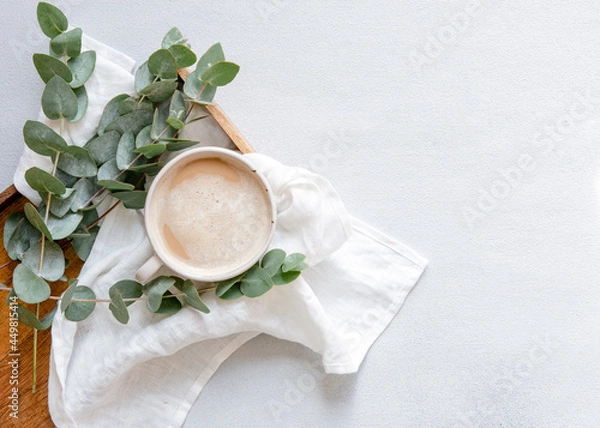 Fototapeta Workspace with leaves eucalyptus, cup of coffee on white background. Art frame. Flat lay, overhead view, home workspace