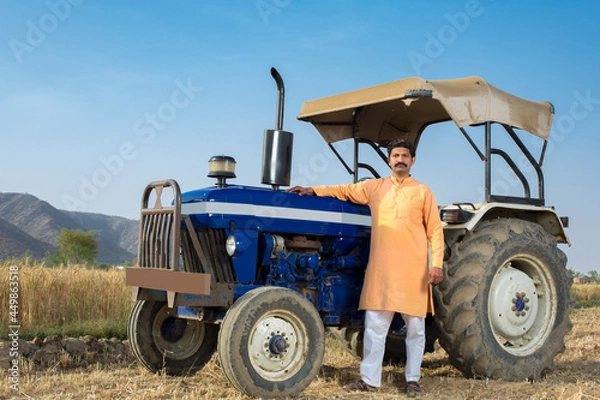 Fototapeta Happy Indian farmer with tractor on agricultural field