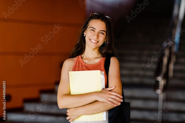 Fototapeta Portrait of a smiling girl with a folder in her hands