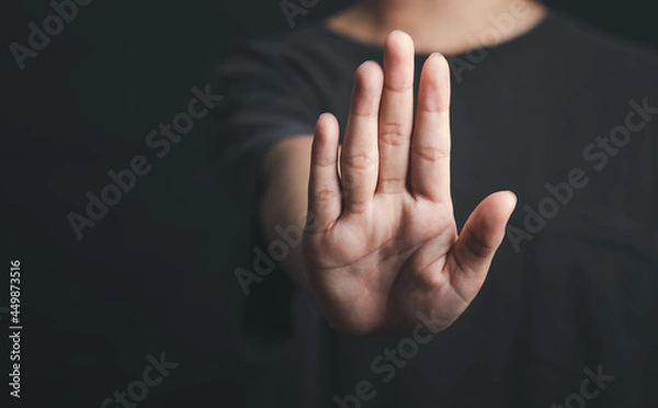 Fototapeta Human hand show stop sign, Hold arm one person stop gesture in dark tone.