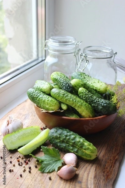 Fototapeta Fresh cucumbers on a wooden table. Dill, garlic and spices. Preparation of pickled cucumbers. preservation of fresh homemade cucumbers. Selective focus. nature