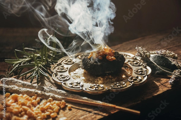 Obraz Charcoal burning with incense, incense resin, rosemary, laurel, lavender on a rustic wooden table, 
smudge stick, smudging, energetic cleansing and smoking.Sahumar
