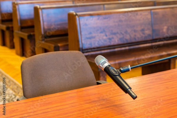 Fototapeta Closeup of microphone in the courthouse. Justice system, witness testimony. Nobody