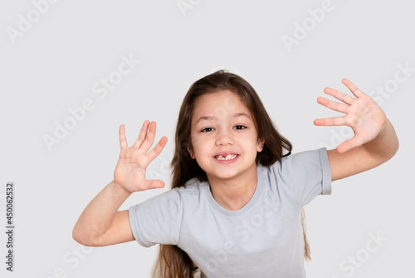 Fototapeta Portrait of a beautiful happy laughing child girl, close-up. Happy childhood concept, smiling. Little girl in white or grey blank t-shirts.The tooth is growing in the wrong place.